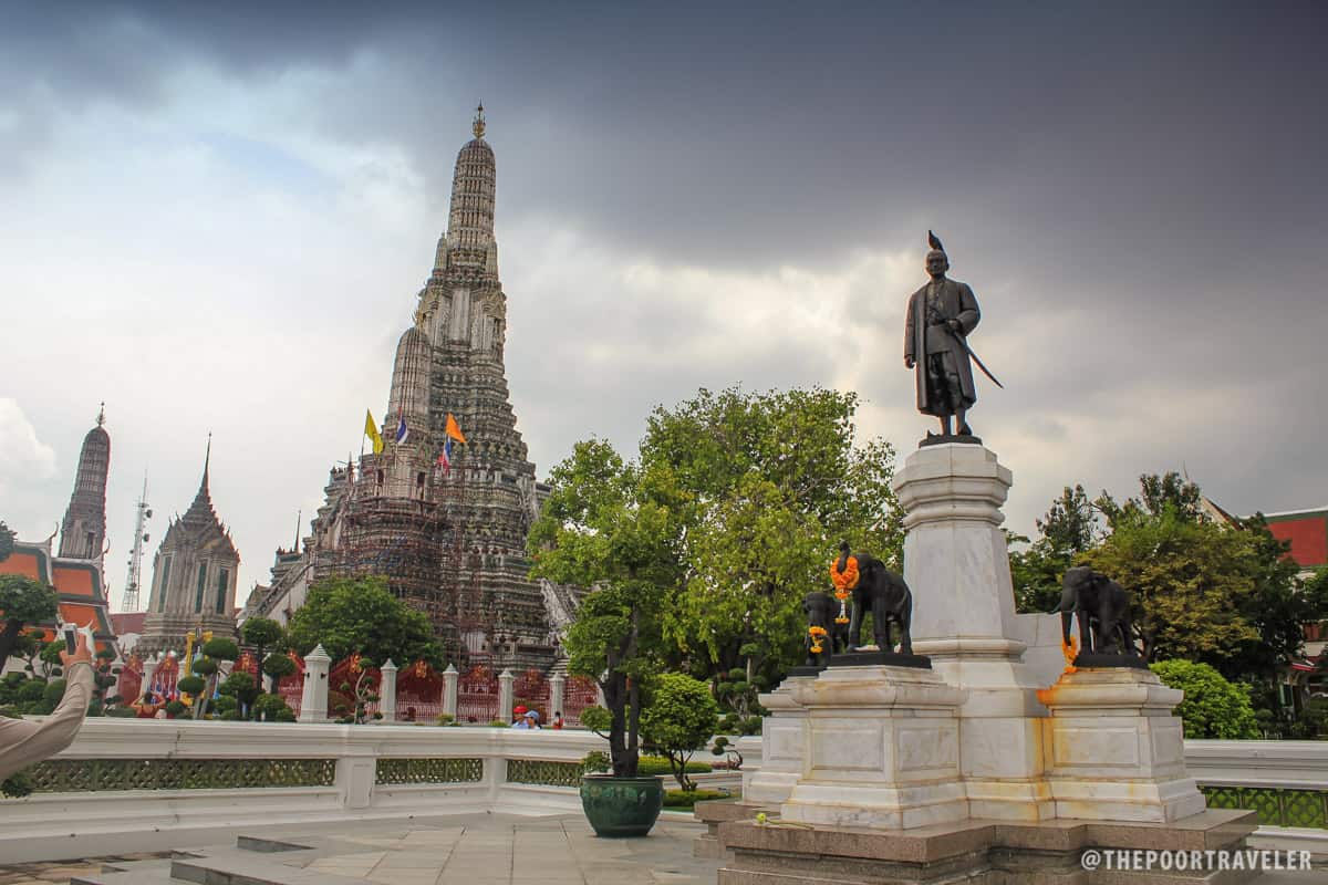 Statue of King Rama beside the prang of Wat Arun