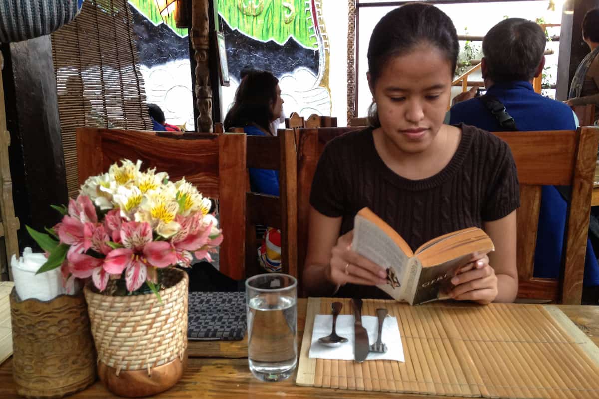 My friend Mica reading her time away while waiting for our meals