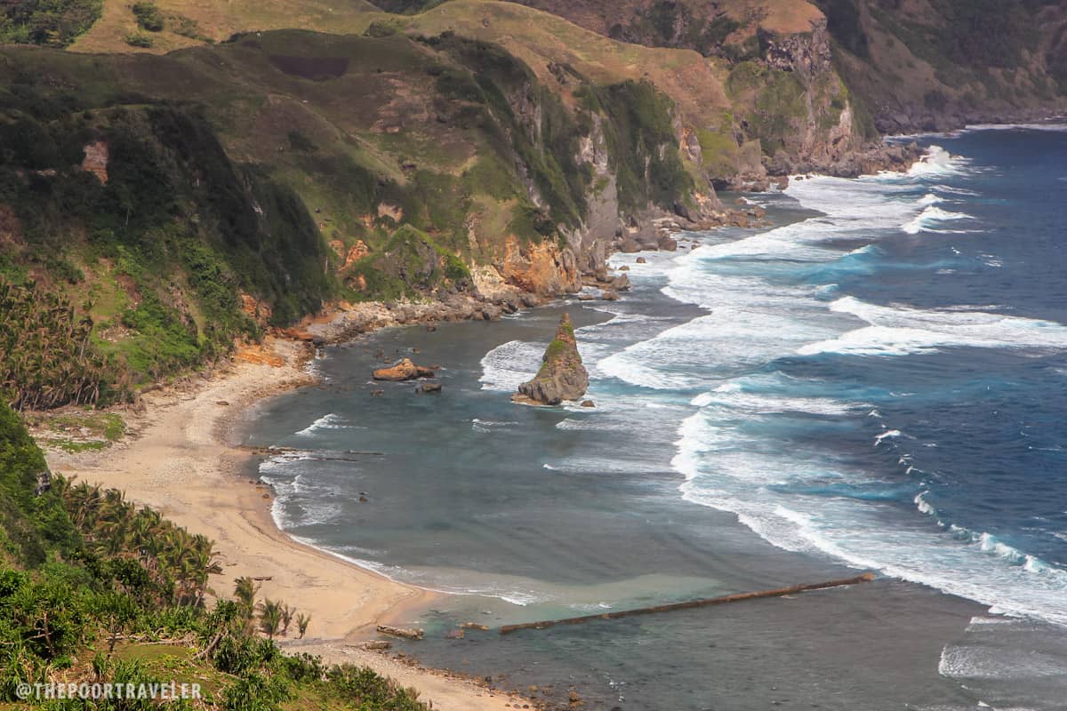 A cone-shaped islet catches the attention of tourists admiring the view.