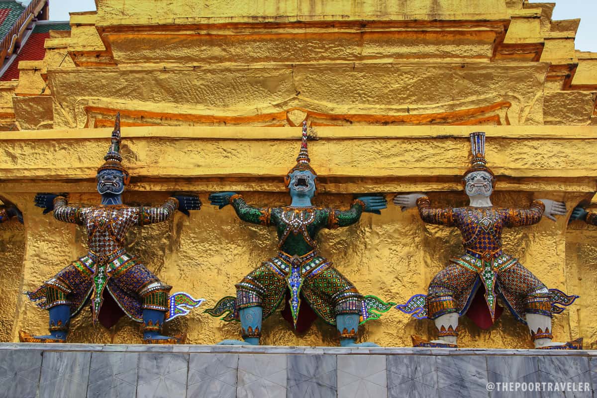 Statues of demons lifting the chedi at the Temple of the Emerald Buddha