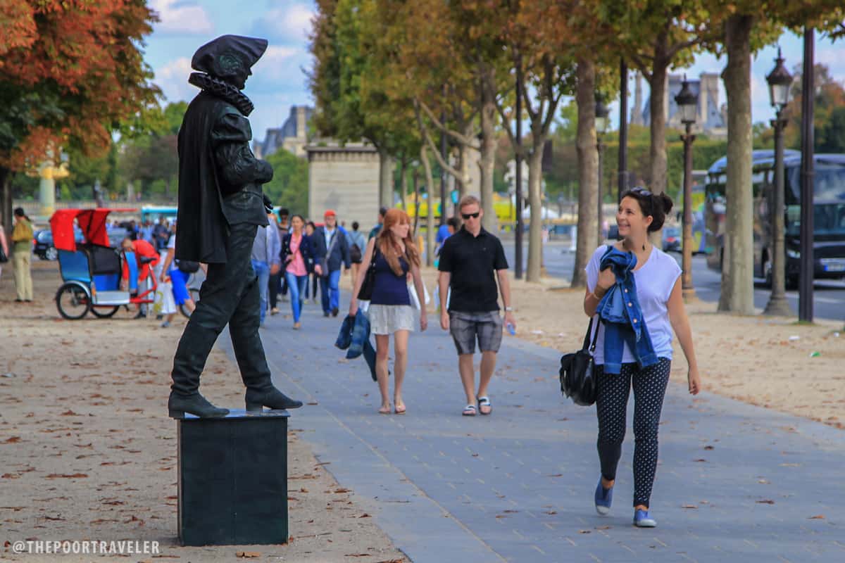 A human statue amuses a passerby