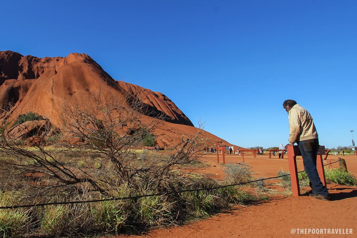 A local watching tourists climb Uluru